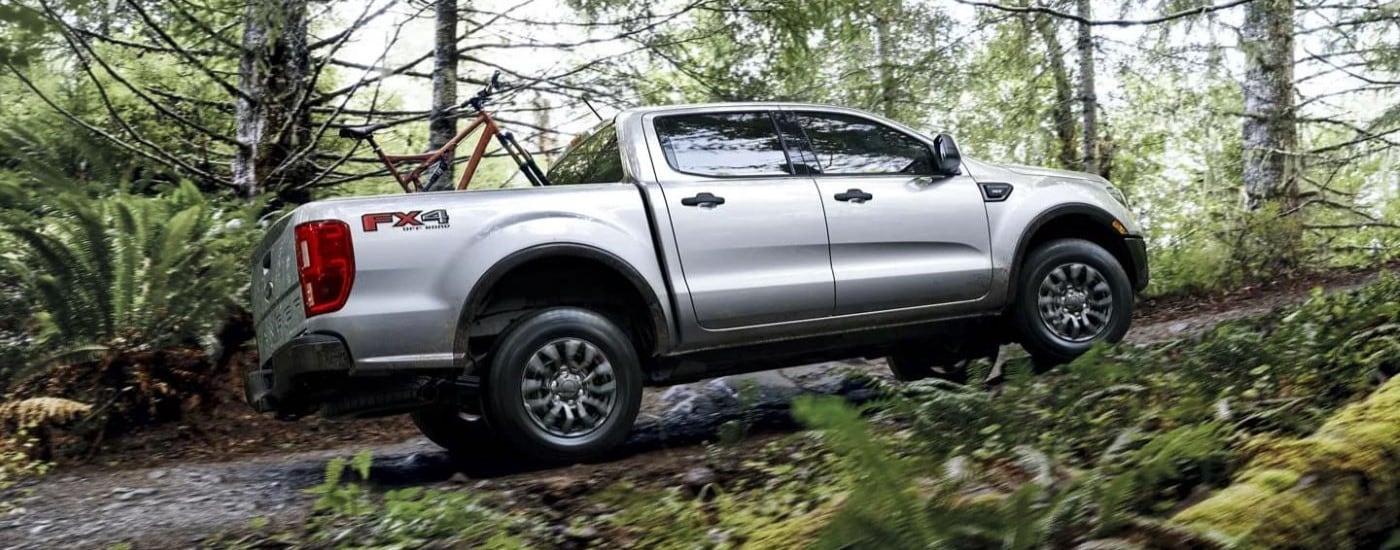 A silver 2023 Ford Ranger XLT FX4 driving in the woods.