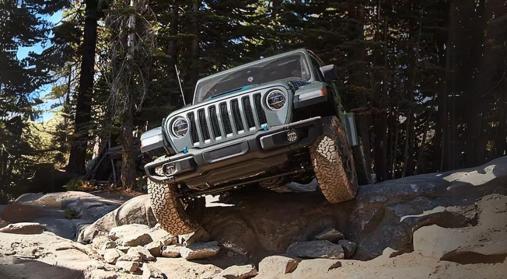 2024%20Jeep%20Wrangler%204xe%20-%20Rocks%202.jpg A grey 2024 Jeep Wrangler 4xe is shown off-roading.