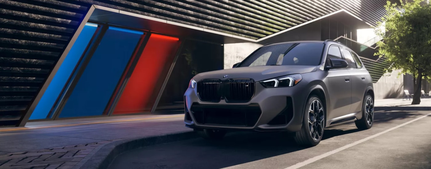 Grey 2026 BMW X1M parked in front of a building