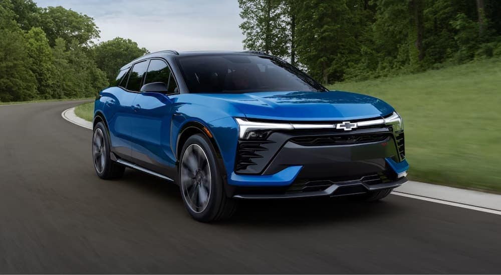 A blue 2024 Chevy Blazer driving down a road.