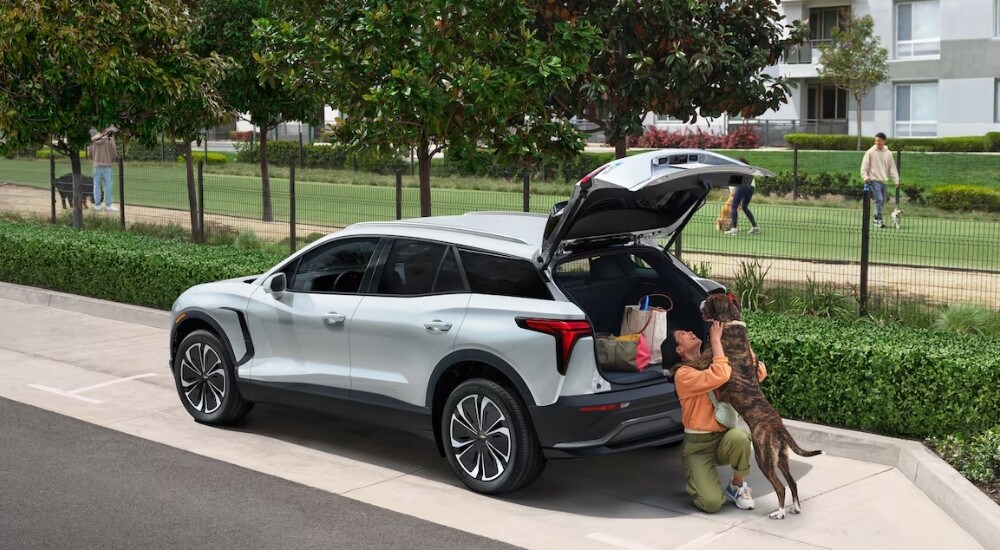 Car%20Dealer%20Near%20Duluth%20-%202025%20Chevy%20Blazer%20EV%20-%20Dog%202.jpg A person is shown playing with a dog near a white 2025 Chevy Blazer EV.