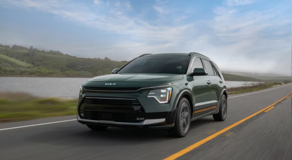 Green 2026 Kia Niro EV driving on an empty road