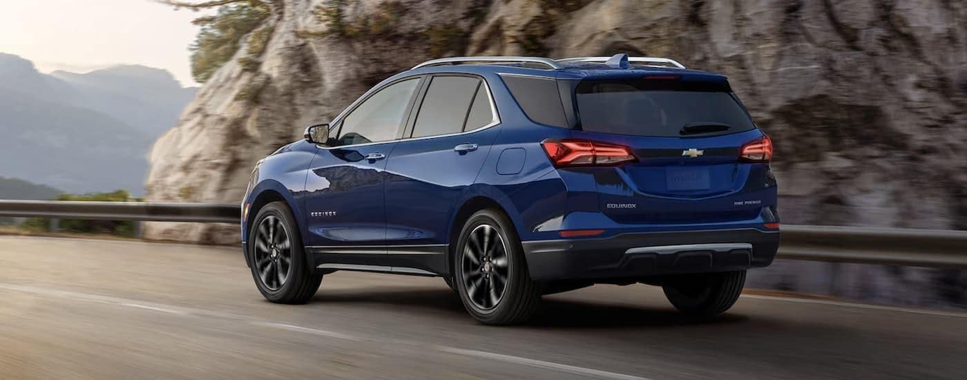 Blue 2022 Chevy Equinox driving to a car dealership near Cary.