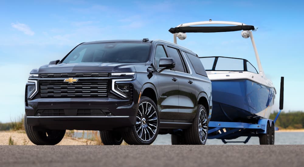Black 2026 Chevy Suburban towing a boat.