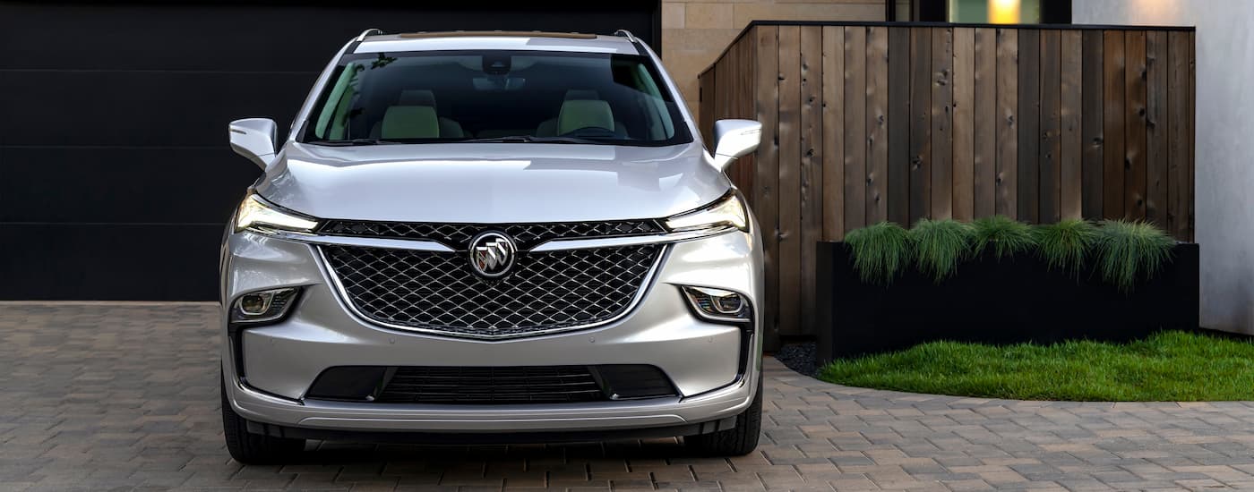 A front view of a grey 2022 Buick Enclave Avenir parked in a driveway.