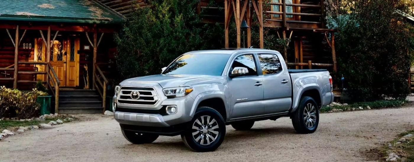 Grey 2023 Toyota Tacoma Limited parked near a cabin