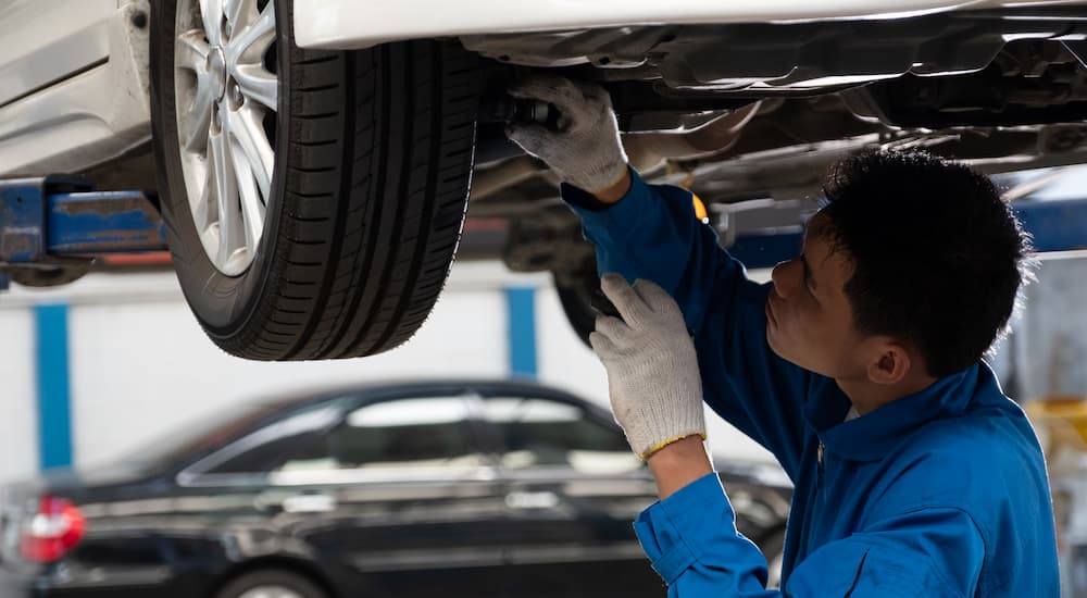 A mechanic is inspecting a vehicle's suspension.