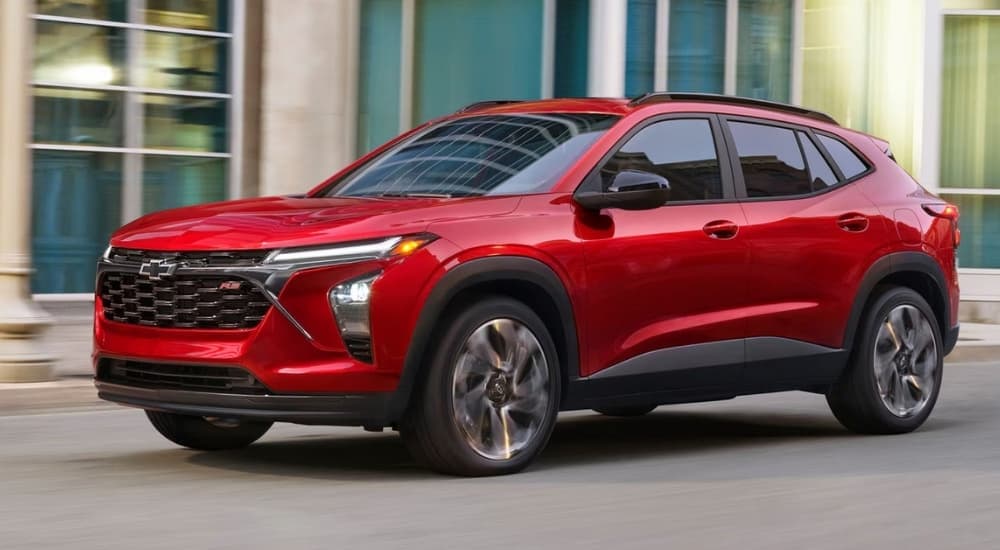 Red 2026 Chevy Trax driving down a city street.