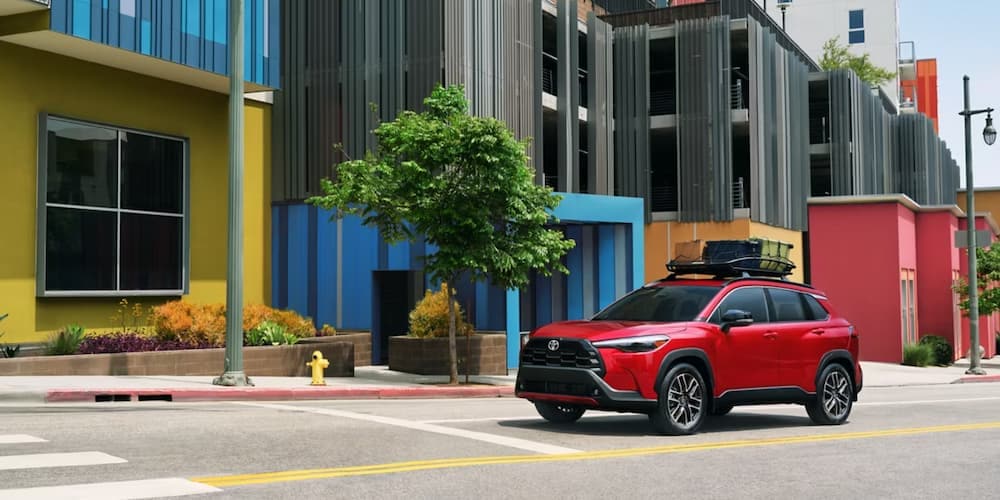 A red 2026 Toyota Corolla Cross parked in a city