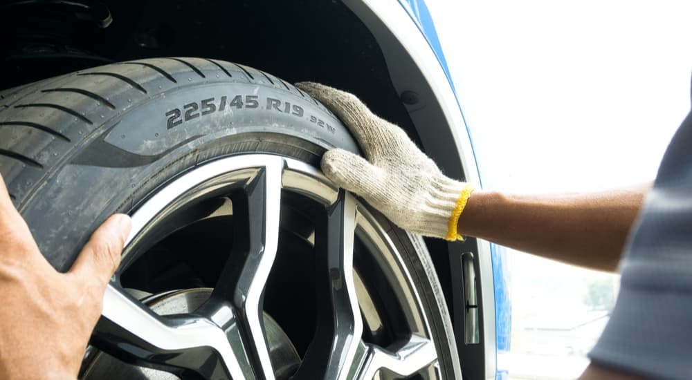 A close up of a tire and rim being replaced on a car.