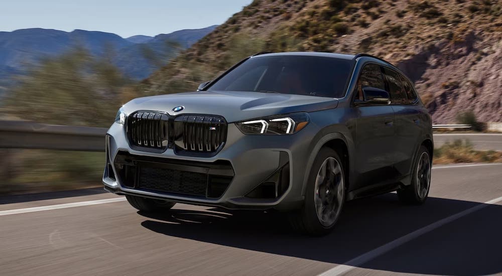 A grey BMW X1 driving on a mountain road from an SUV dealership near Wilmington.