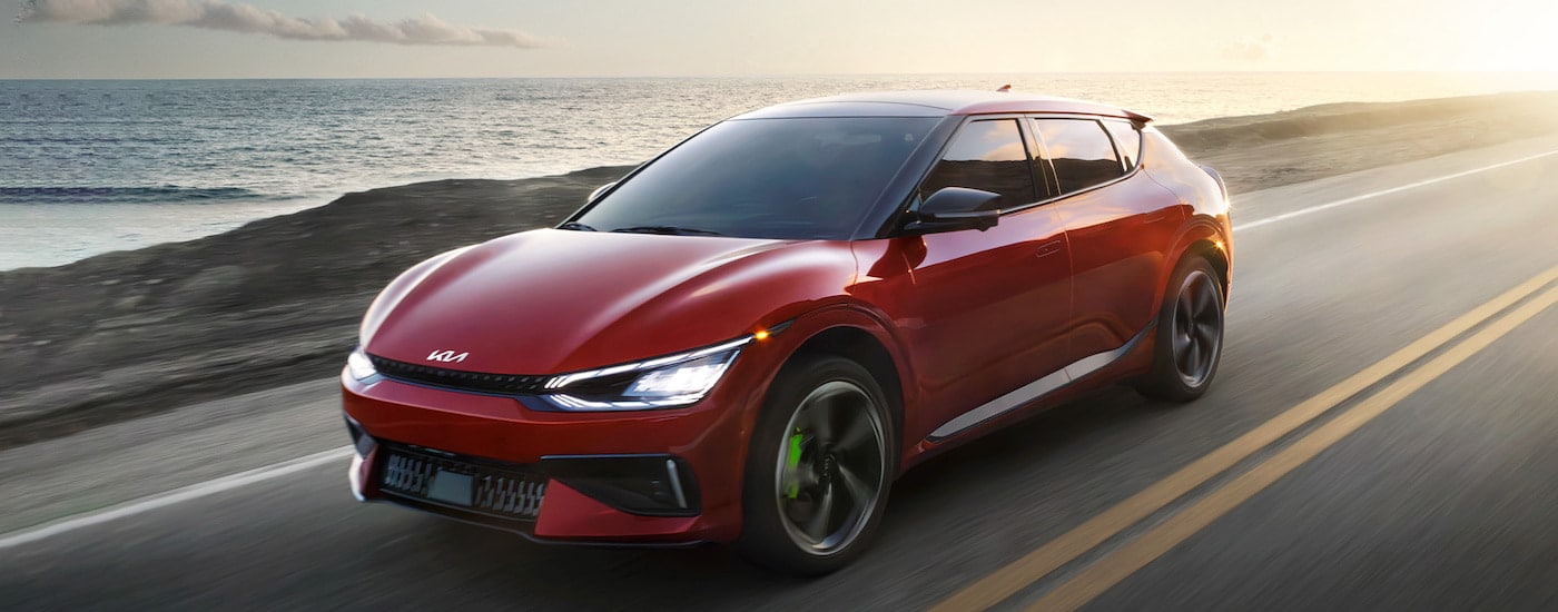 A red 2024 Kia EV6 is shown from the front at an angle after leaving a dealer that has new electric vehicles in Charlotte.