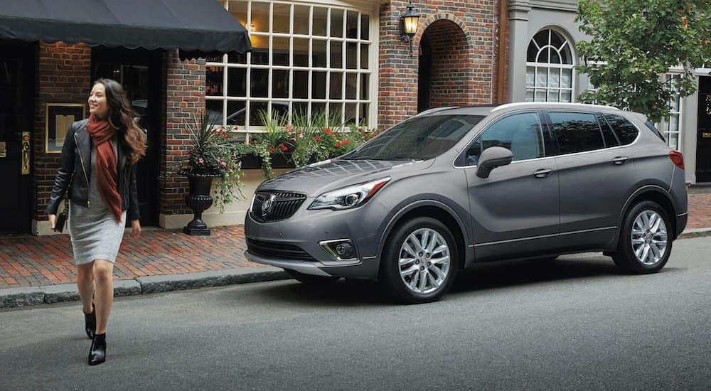 A gray 2020 Buick Envision is shown parked near city curb.