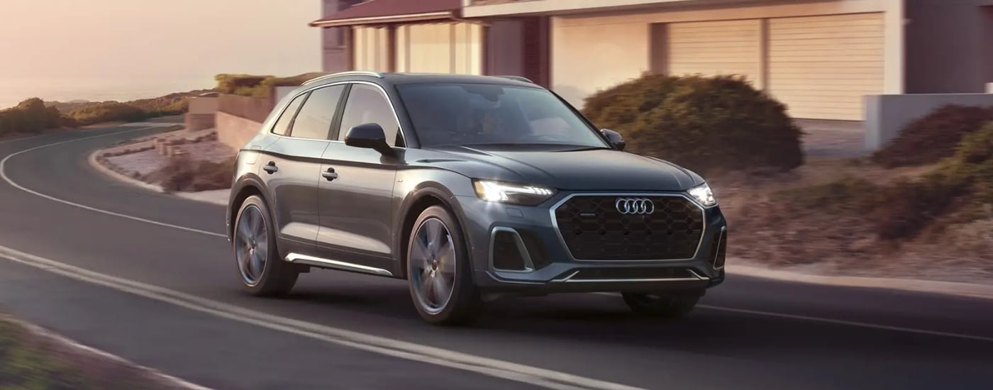 Grey 2023 Audi Q5 driving to a car dealer near Concord