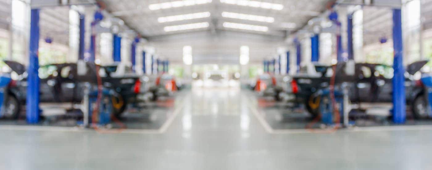 A blurry view of a car service center full of vehicles.