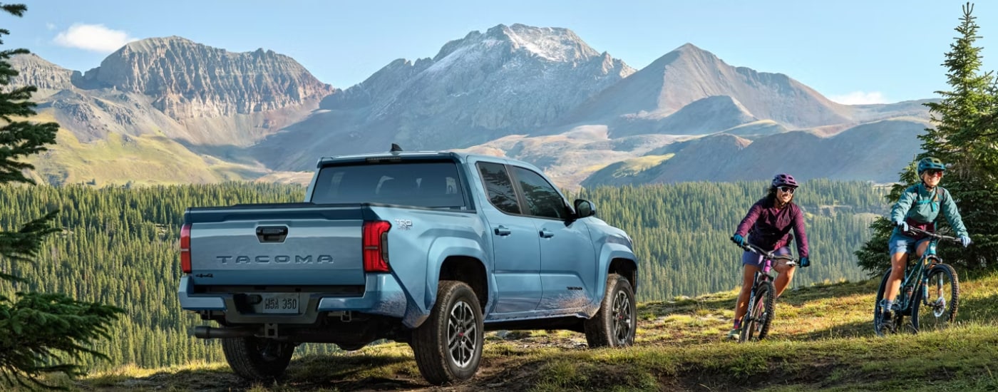 Rear of a blue 2024 Toyota Tacoma parked off-road