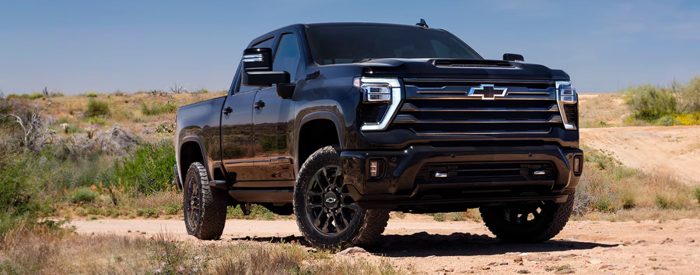 Black 2026 Chevy Silverado 2500 HD parked off-road at an angle