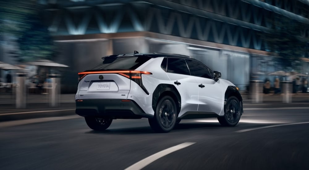 Car%20Dealer%20Near%20Duluth%20-%202025%20Toyota%20bZ4X%20Nightshade%20-%20Corner%202.jpg A white 2025 Toyota bZ4X Nightshade is shown driving to a car dealer near Duluth.