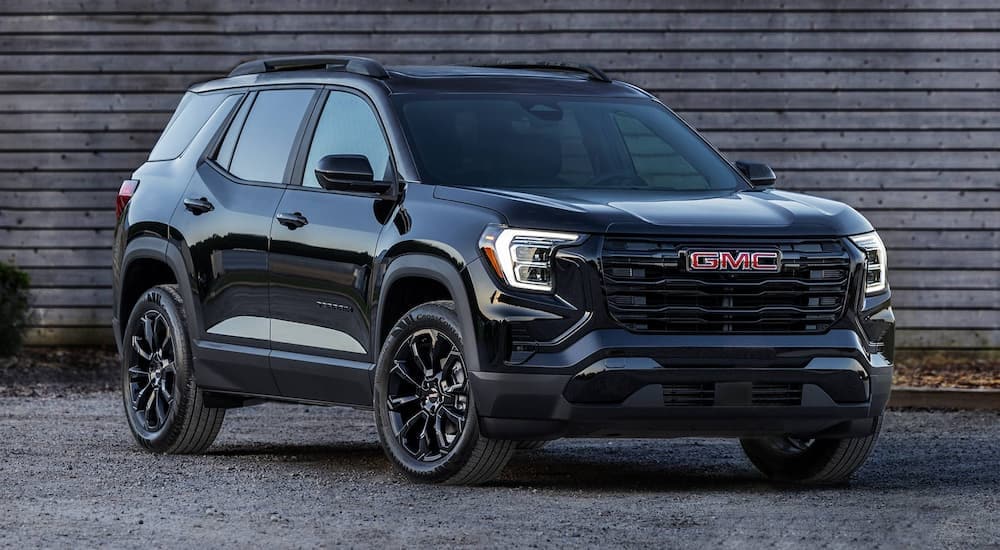 Black 2025 GMC Terrain parked by a dealer with SUVs for sale in Raleigh.