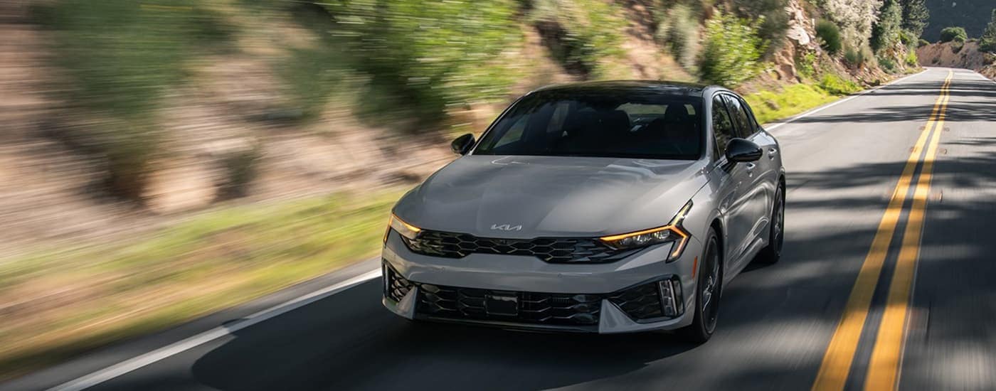Grey 2025 Kia K5 driving on a road