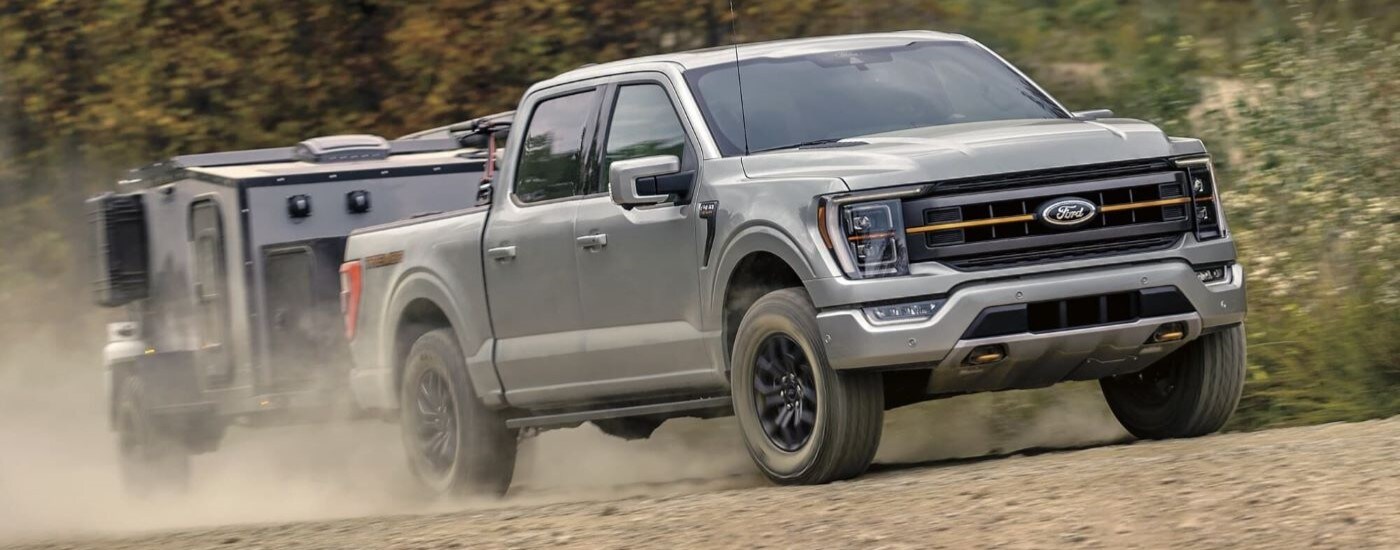 A grey 2024 Ford F-150 Tremor towing a trailer.