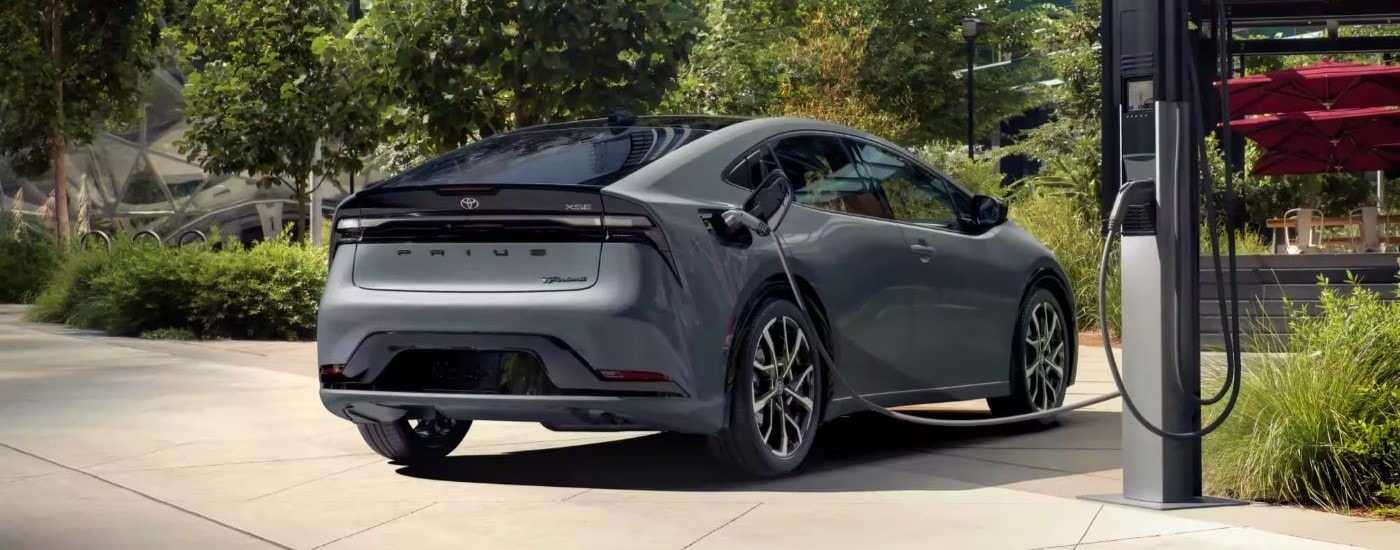 A grey 2023 Toyota Prius Prime XSE Premium is shown from the rear charging.