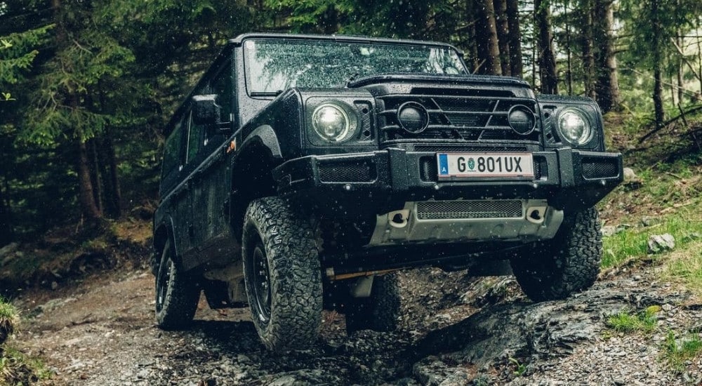 A black 2025 INEOS Grenadier Station Wagon is shown off-road.