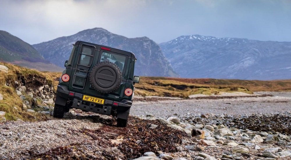 Black 2025 INEOS Grenadier driving on a lake shore