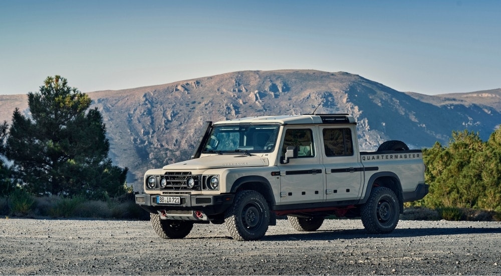 A white 2025 INEOS Grenadier Quartermaster is shown parked on gravel.