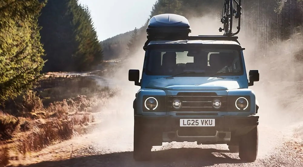 Blue 2025 INEOS Grenadier driving off-road.