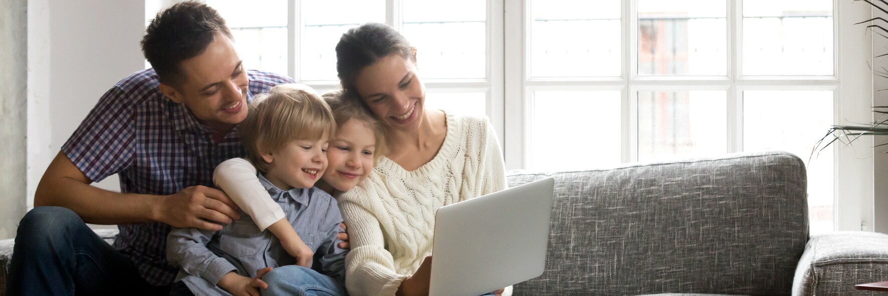 Young family on the couch looking at the laptop