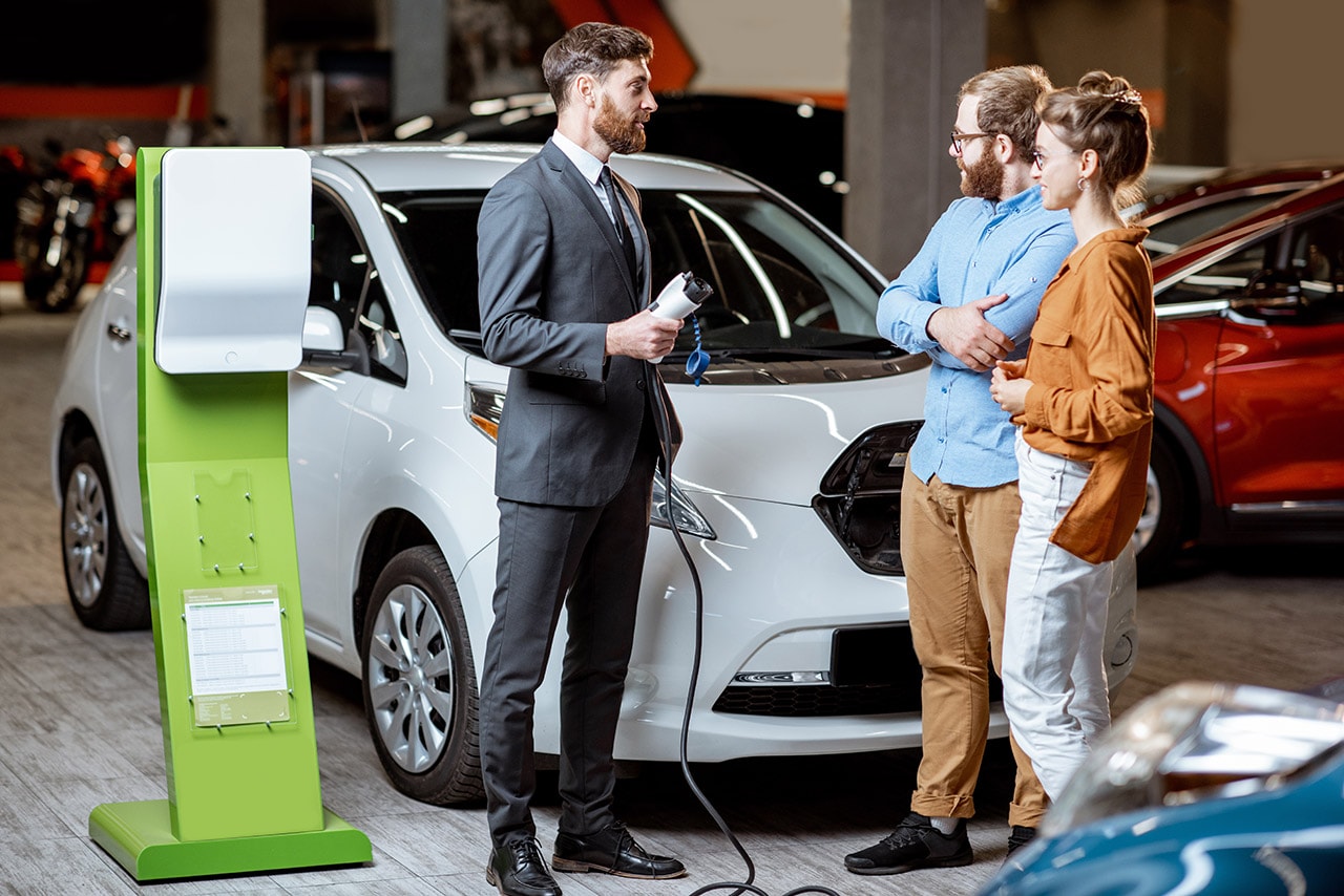 couple with car dealer in front of a PHEV car