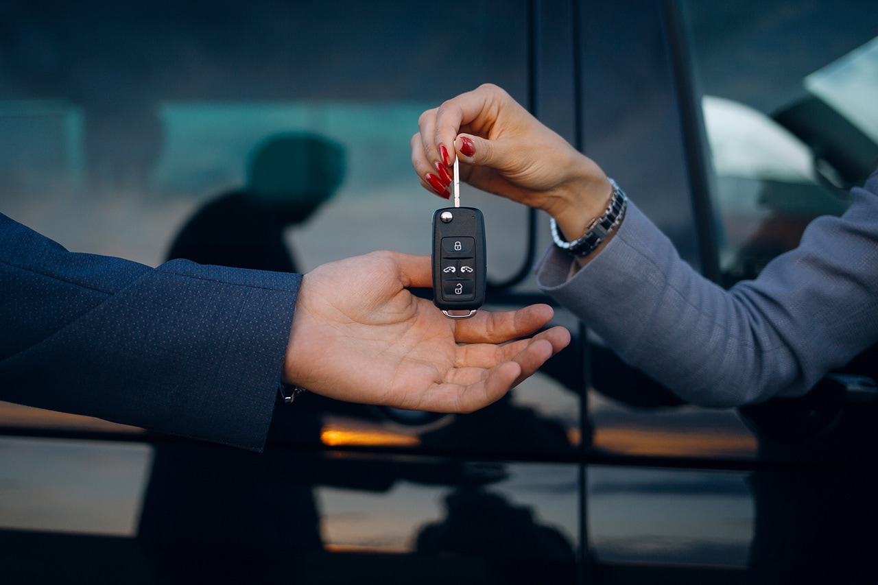 car key being passed from the hand of one person to another