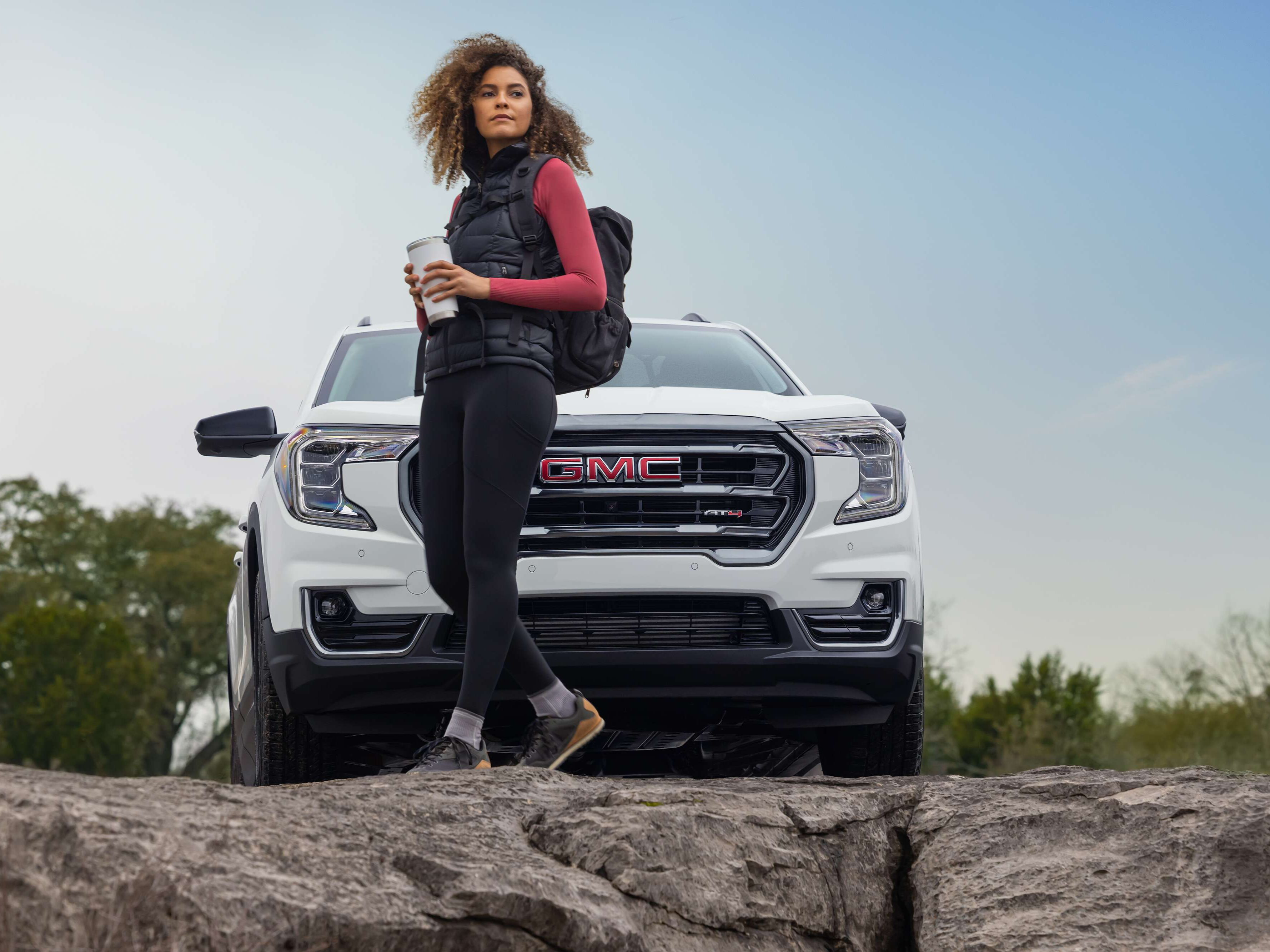 Woman standing in front of a white GMC vehicle
