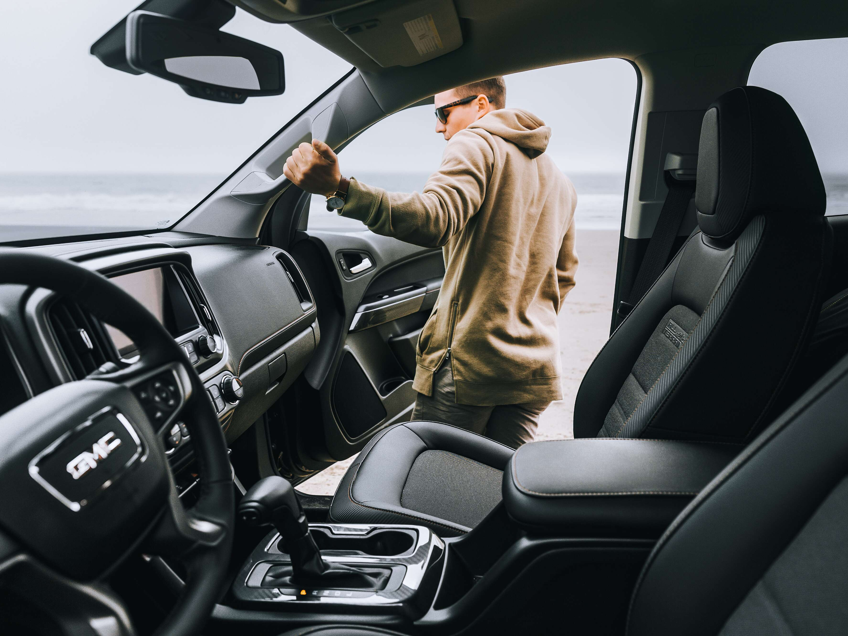 Man getting into a driver seat of a GMC car