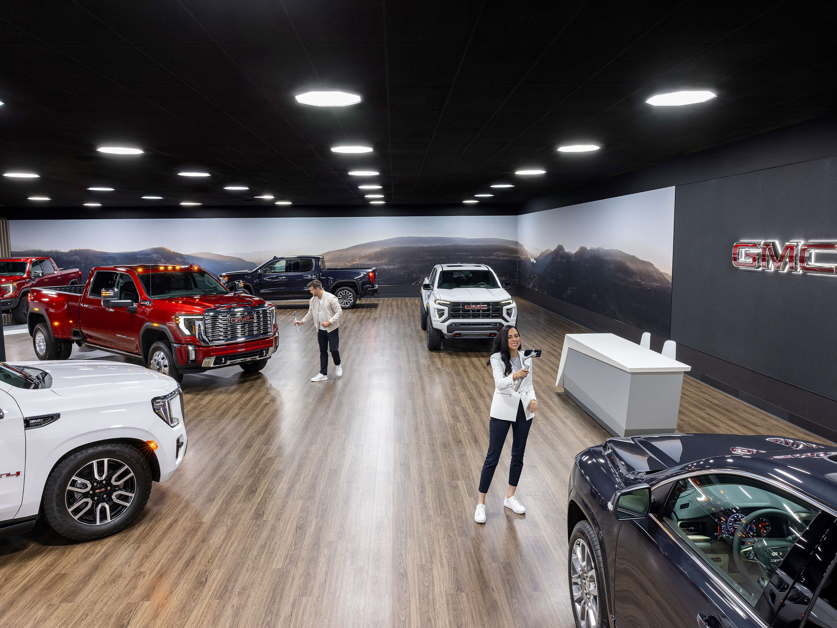 People inside a GMC Dealership showroom with vehicles