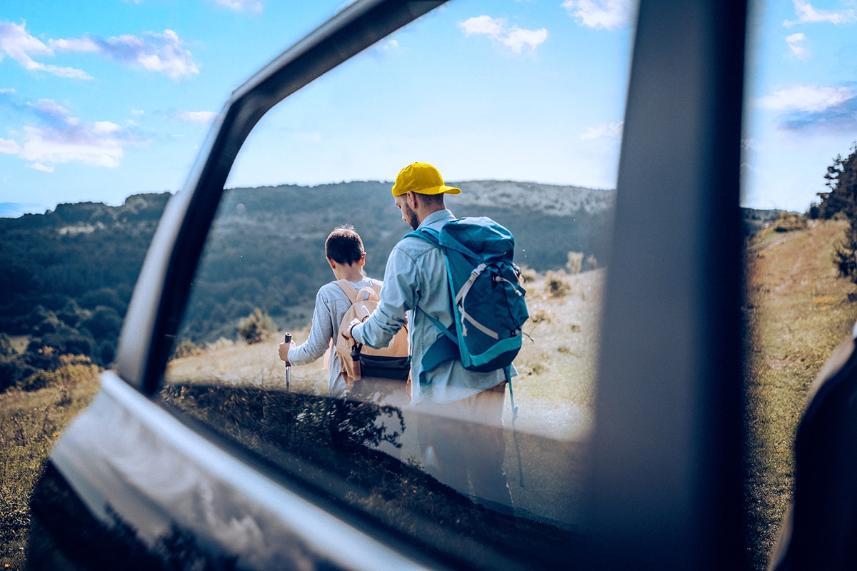 A father and son hiking with hills in the distance