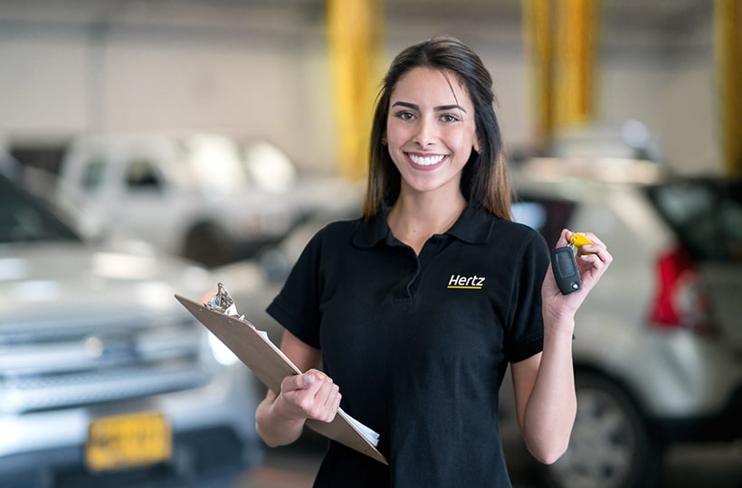 Hertz employee holding a clipboard and a set of car keys