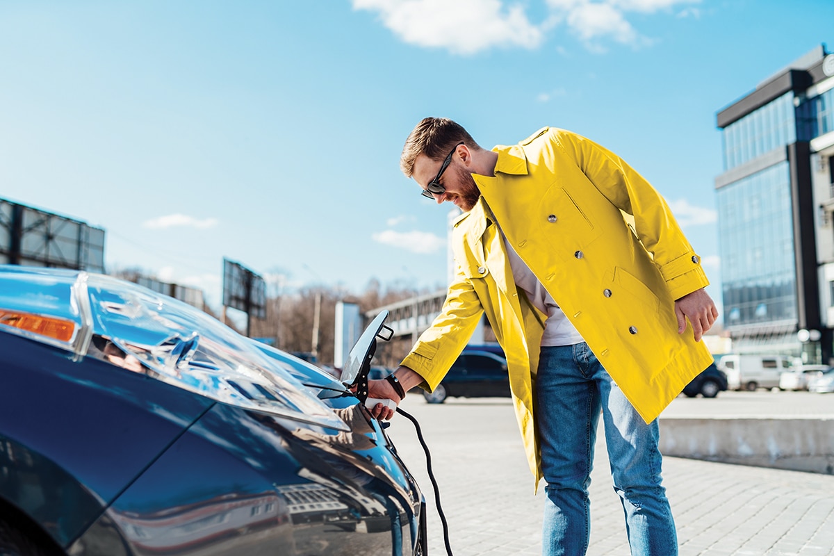 A man plugging in an electric vehicle