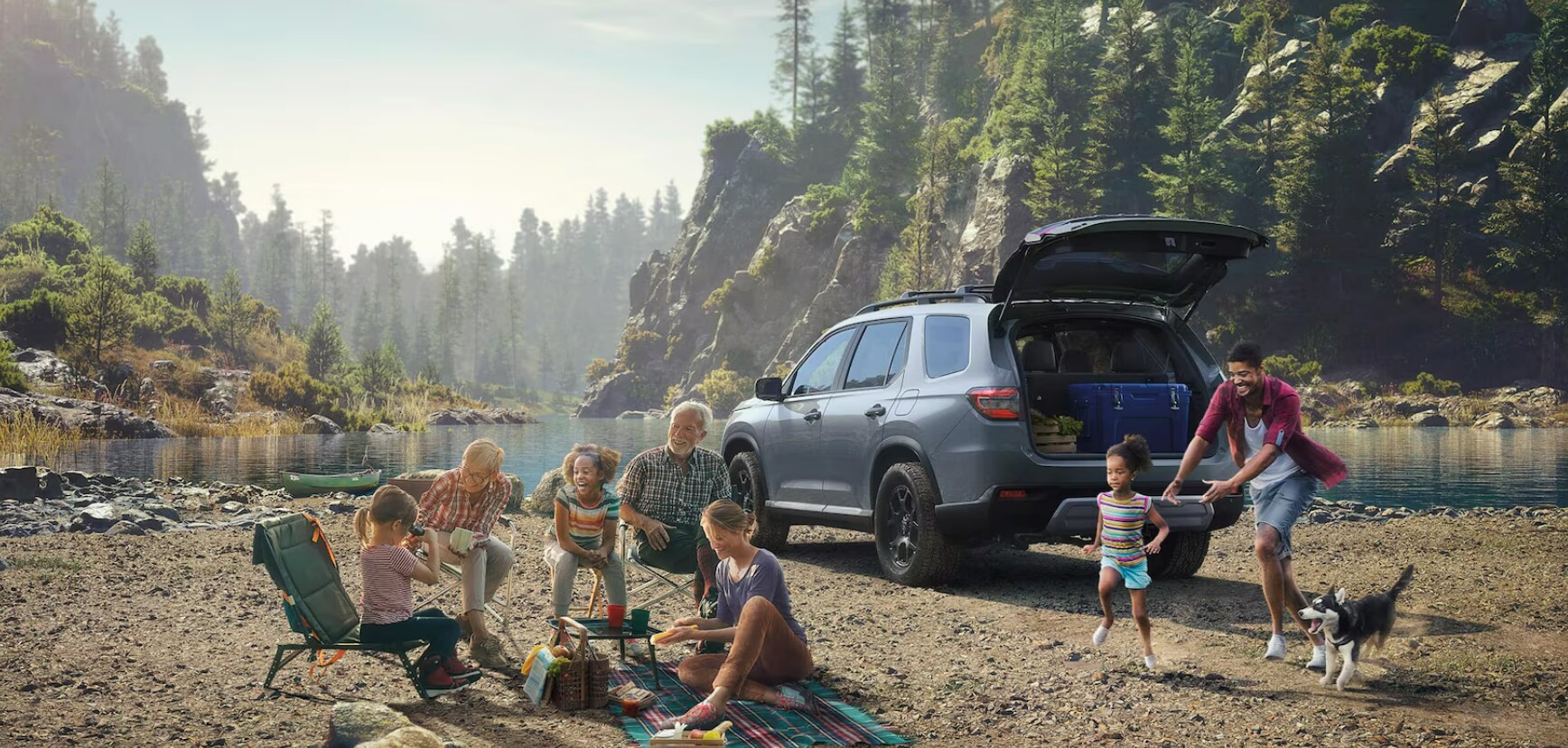 Family having a picnic at the lake with a 2025 Honda Pilot off to the right.