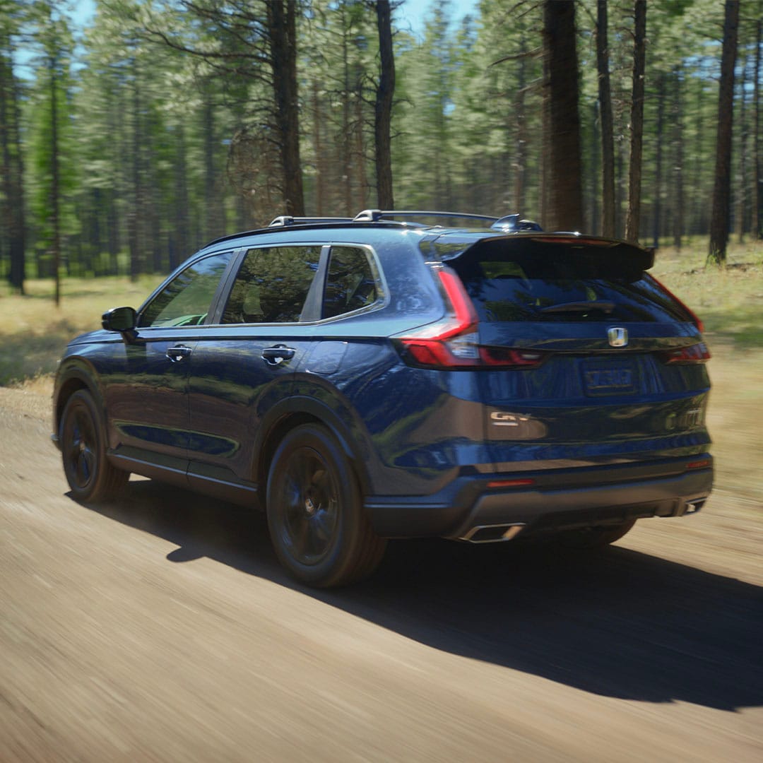 Blue 2027 Honda CR-V driving on a forest road near Glenwood Springs, CO