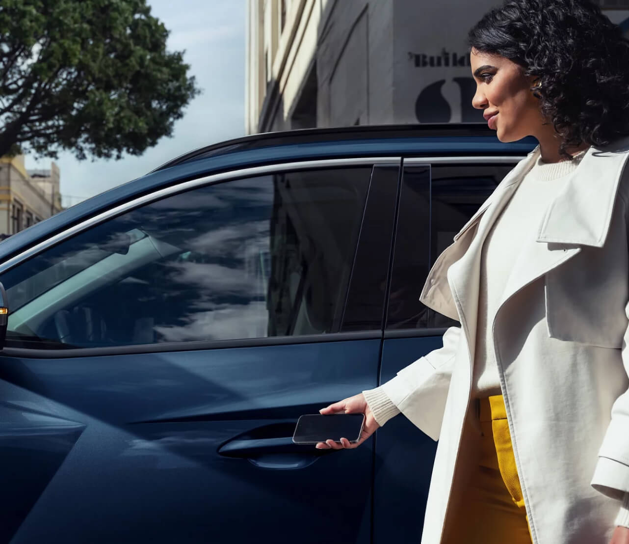 A woman opening the driver door of a blue Hyundai SUV.