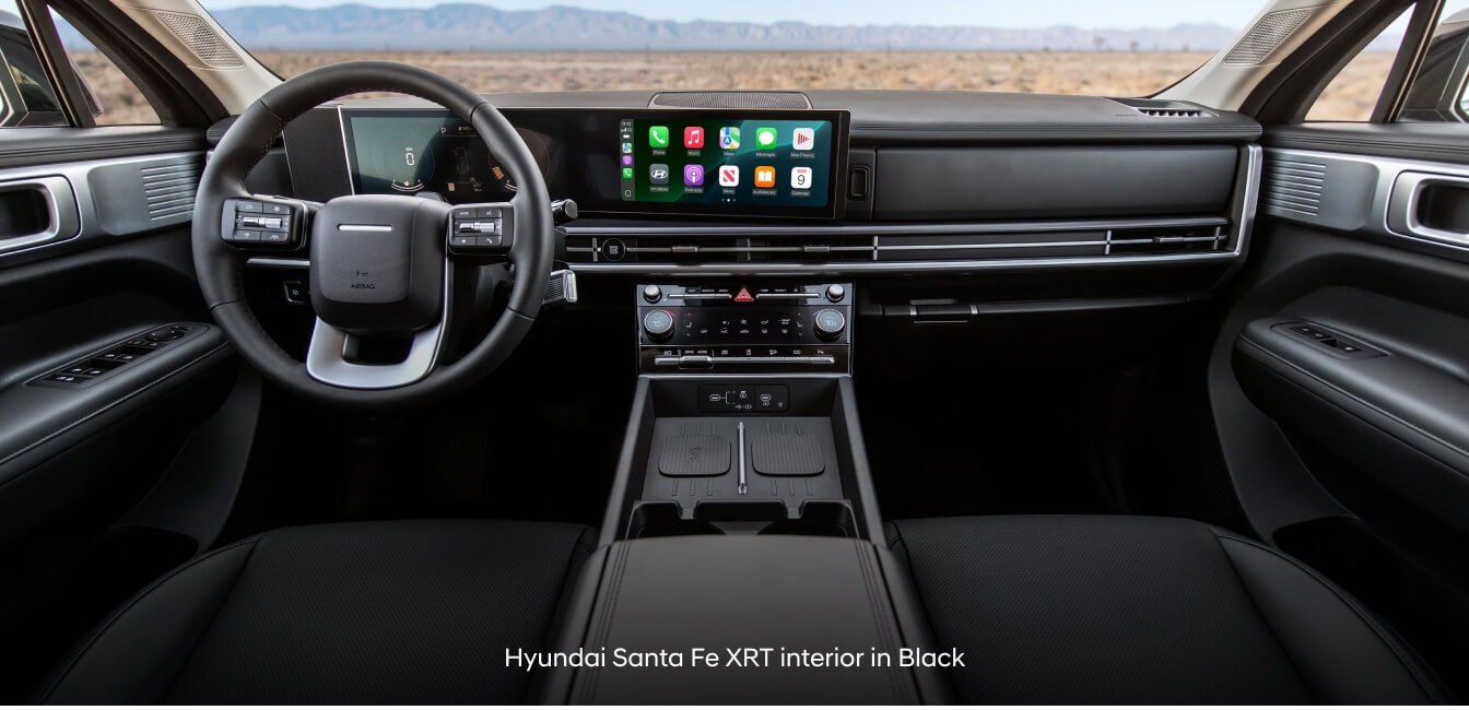 Hyundai Santa Fe XRT in Black H-Tex Leatherette with dual wireless chargers facing desert landscape.