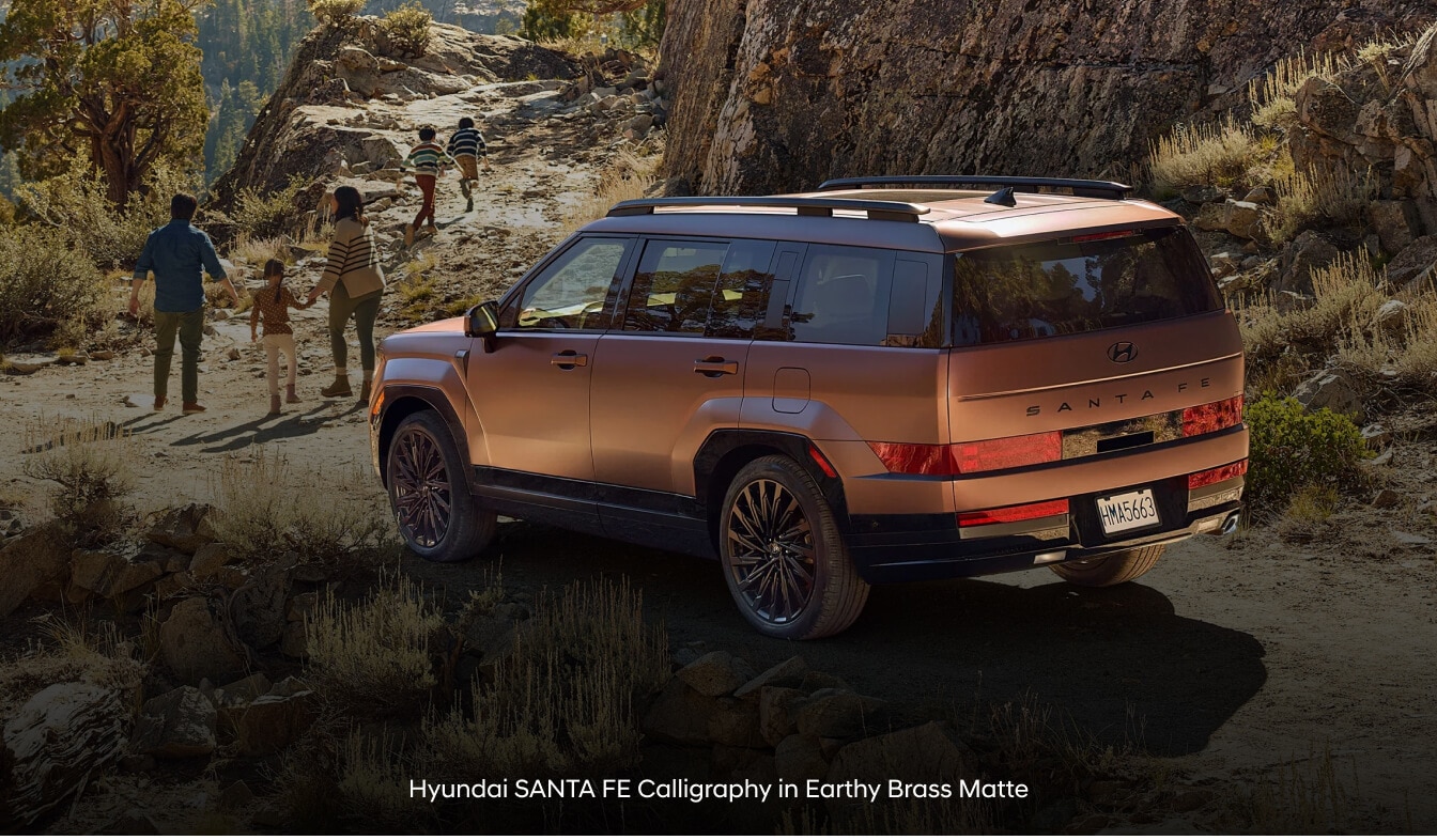 Hyundai Santa Fe Calligraphy in Terracotta Orange with roof side rails on rocky trail.