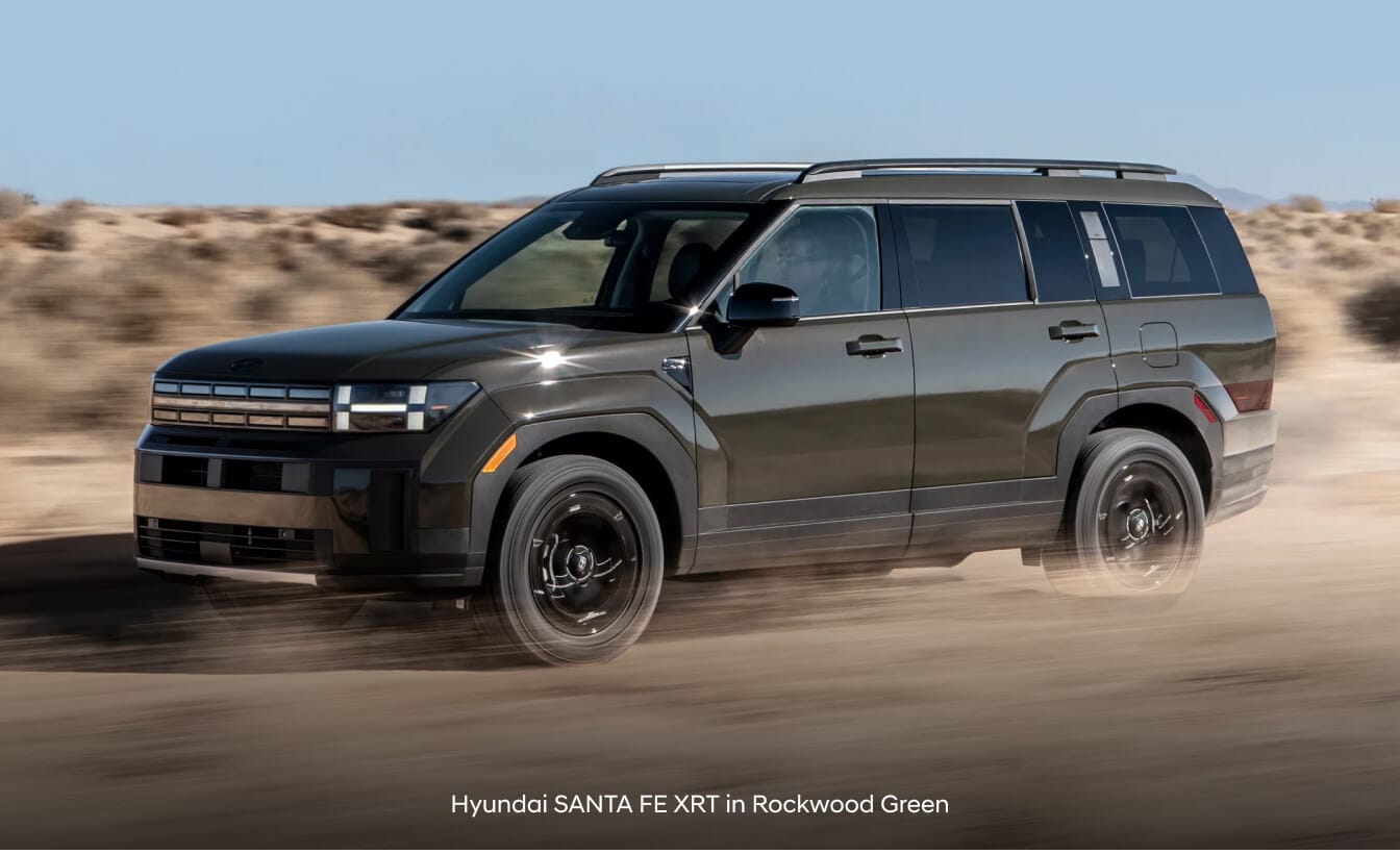 Hyundai Santa Fe XRT in Rockwood Green with roof side rails on desert dirt terrain.