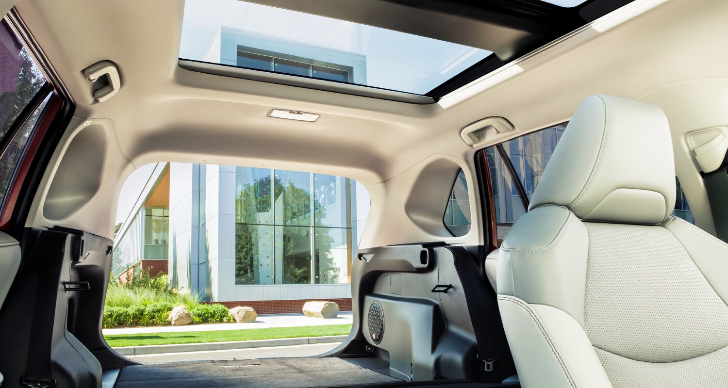 Glancing view from the front passenger seat of the rear cargo space area with dual sunroofs inside the 2021 Toyota RAV4 Hybrid