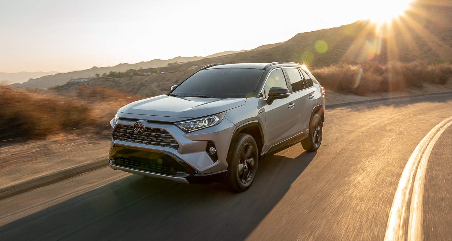 New 2021 Toyota RAV4 Hybrid SUV driving around the bend of a curvy highway