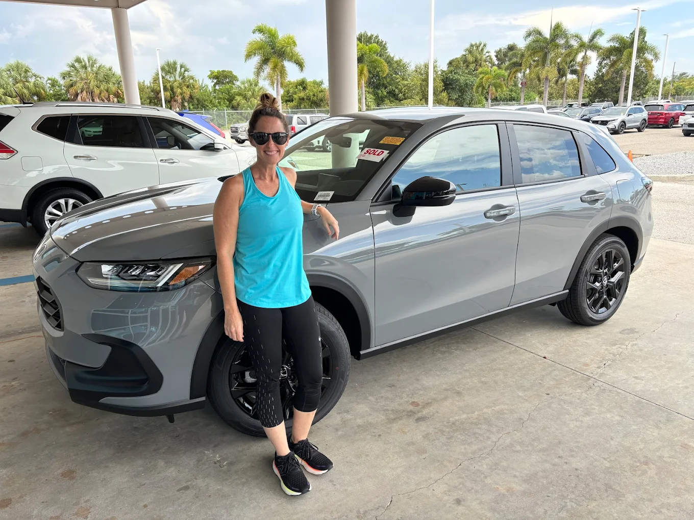 Woman in front of her new pre-owned Honda vehicle