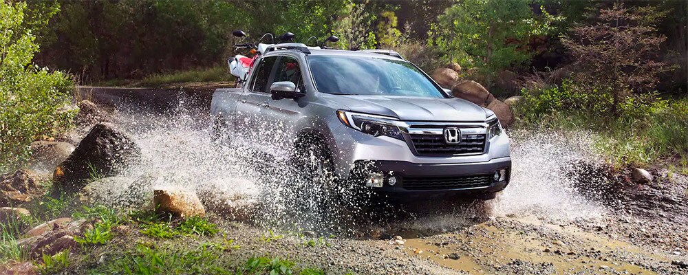 2019 Honda Ridgeline with ATV in the back splashing in the water