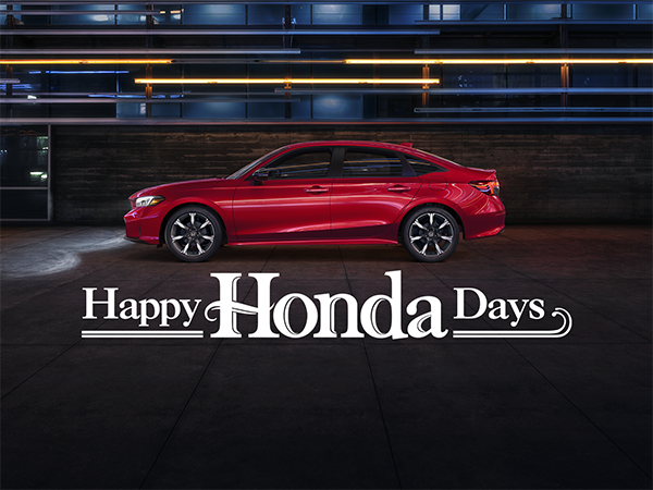  Honda sales representative explaining current lease specials to a customer in the Jim White Honda showroom in Toledo, OH